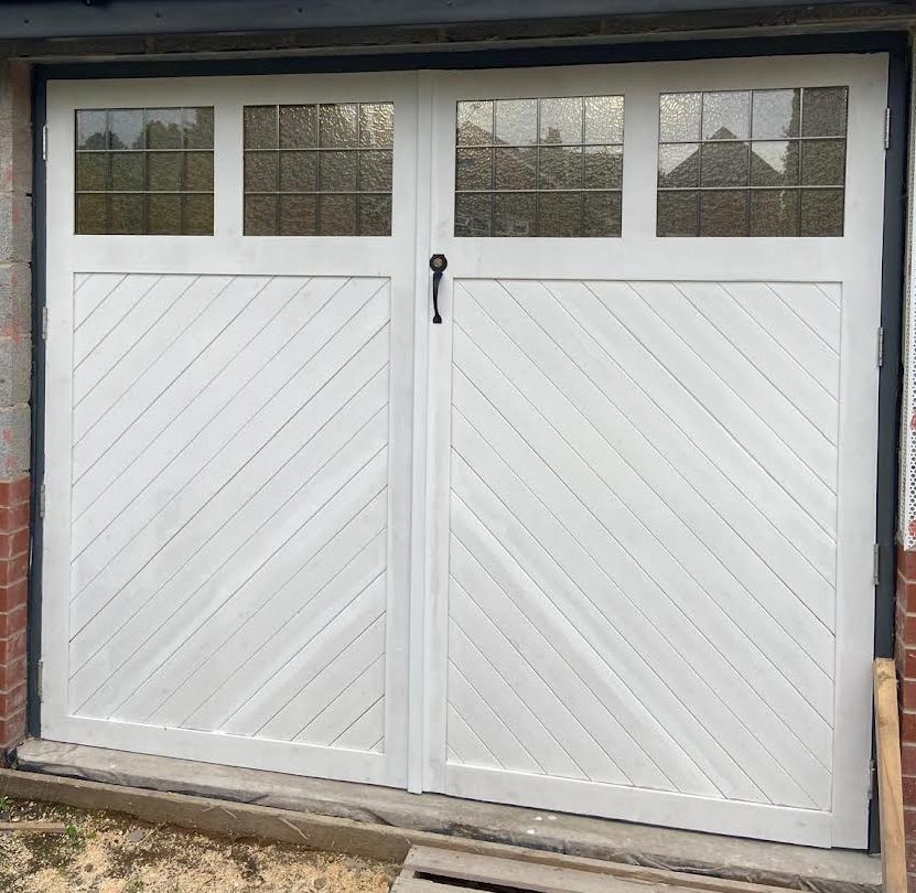 Finished white handmade timber garage doors with glazed top panels, built by Phix Pro
